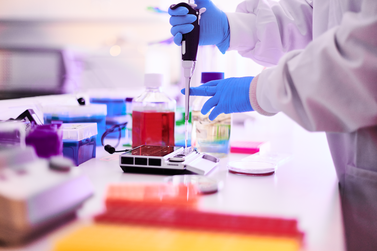 Scientist manipulates a pipette on a lab bench